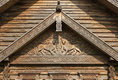 Carved pediment of a wooden house with rich ornament: house carving decorates the facade and emphasizes the architecture