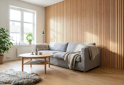 Beech wood slats on an accent wall in a Scandinavian living room interior with a gray sofa
