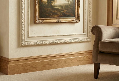 Tall oak baseboard and decorative MDF frame with carving on the wall in a classic interior