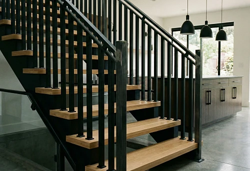 Staircase with expressive wooden balusters and contrasting dark accents
