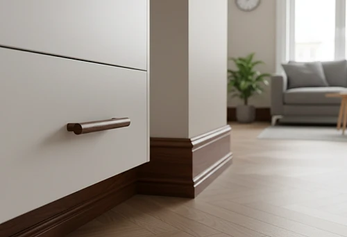 White furniture with a wooden handle and dark wooden skirting against a light interior &mdash; an example of a quick wood-like renovation using wooden handles and floor skirting.