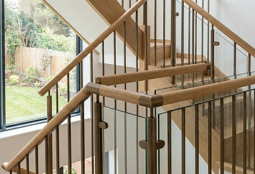 Modern staircase 2026 with round wooden handrails and metal balusters