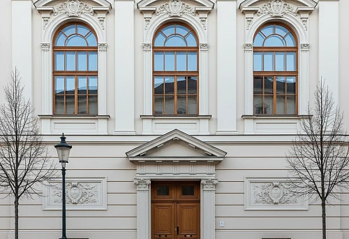 Facade of a classical building with mullions, pediments, and decorative framings above the windows and door