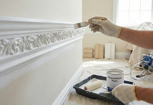 Painting polyurethane molding: painting an ornamental cornice with a brush, carefully following the relief without drips