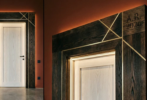 Modern Wooden Architrave 2026 with Lighting and Graphic Metal Inserts Around a Light Door