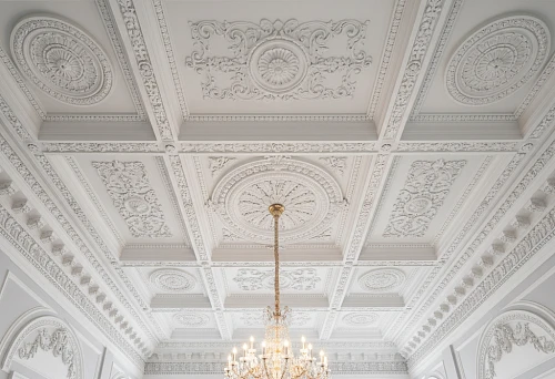 Molded ceiling in a classic interior with a luxurious chandelier