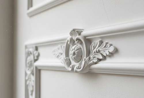 Close-up of polyurethane molding on a wall &mdash; a decorative overlay with a floral pattern and smooth lines, demonstrating an example of real interior design.