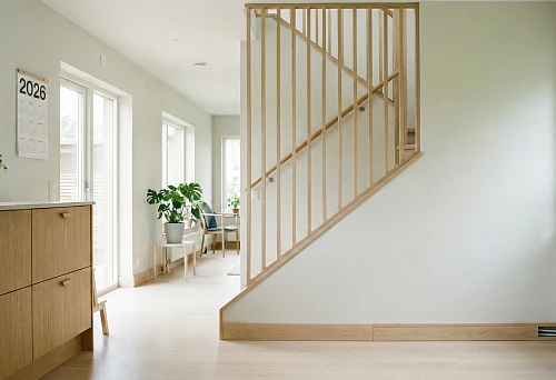 light Scandinavian interior with wooden handles on kitchen fronts and minimalist staircase balusters