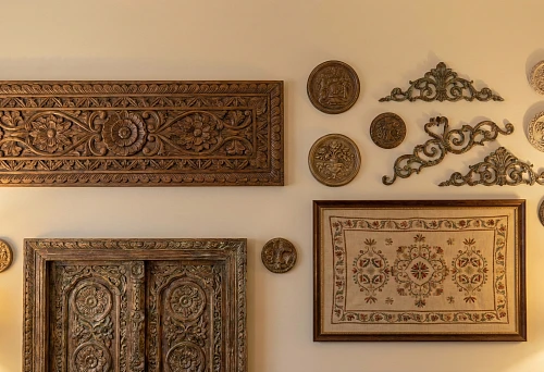 Wall Decor: Carved Wooden Panels and Decorative Overlays with Ornament on a Light Wall in Interior