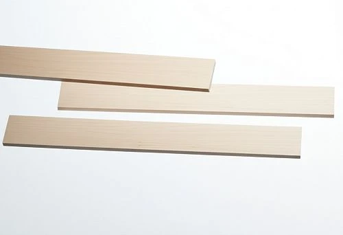 Three light decorative wooden planks of different lengths on a white background