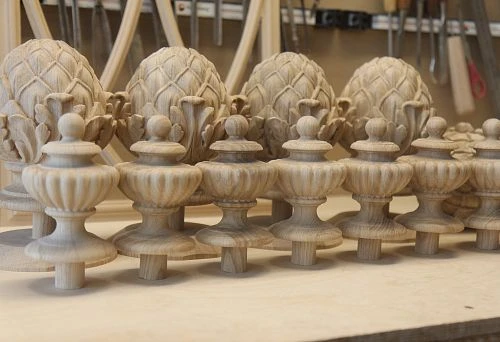 Carved decorative items from natural wood: artistically finished pinecones and miniature vases