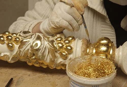 Artistic decoration of decorative element with gold finish &mdash; manual gilding process.