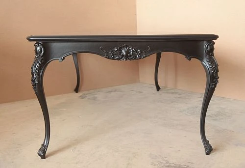 Kitchen table made of natural dark wood with curved carved legs and decorative carving in classic style on a neutral background.