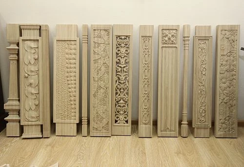A row of square wooden balusters with artistic carving and various decorative patterns