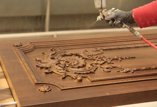 Painting a carved wooden furniture panel using an air spray gun