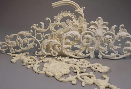 Ceiling molding under the chandelier &mdash; complex white decorative elements made of polyurethane with pronounced relief
