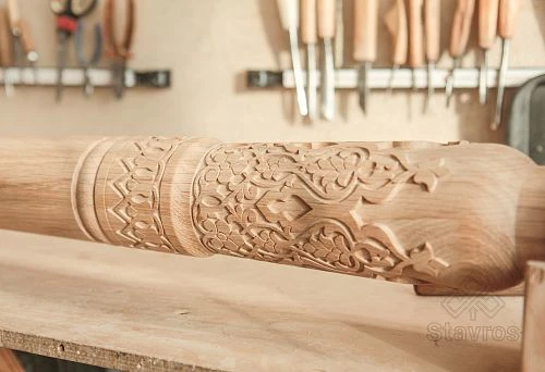 Hand-carved wooden column with artistic ornament, made by turning method