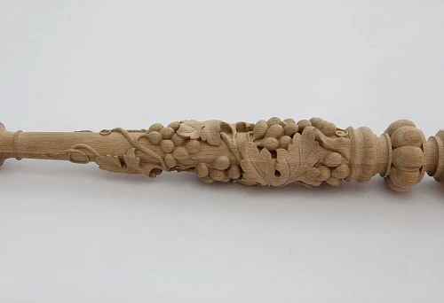 Round carved baluster made of light wood with a three-dimensional grapevine pattern and large leaves, handcrafted.