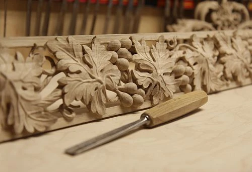 Hand-carved wooden ornament with leaves and acorns