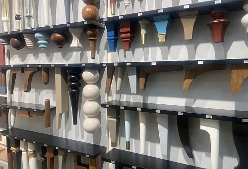 Various wooden furniture legs on display, showcasing elegant shapes and finishes.