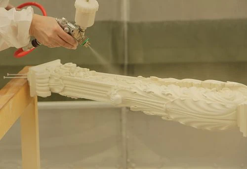 Process of painting a carved staircase post using a spray gun