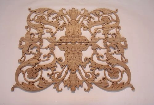 Complex carved wooden panel with symmetrical scrolls and floral motifs, intended for wall decoration