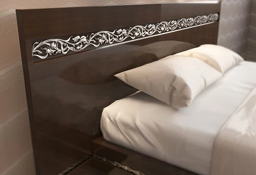 Fragment of a solid wood bed with a carved handcrafted ornament on the headboard