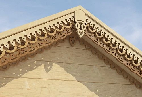 Wooden facade of a house adorned with Russian-style carving featuring traditional patterns
