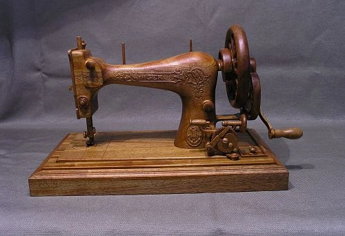 Wooden retro sewing machine replica with manual control.