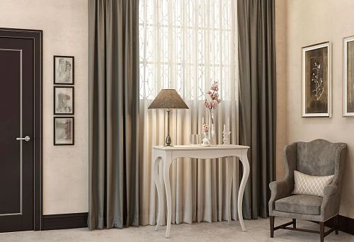 A light wooden table with curved legs, a lamp, and decor against windows with curtains in a cozy modern interior