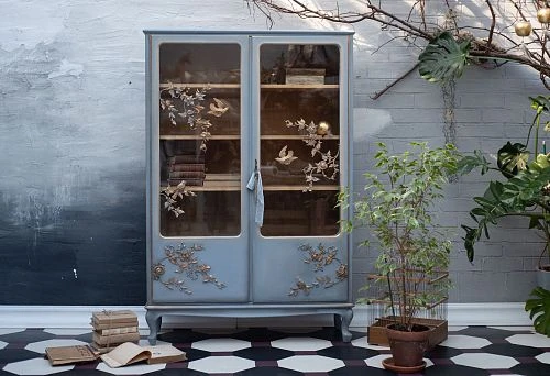 Interior composition with vintage cabinet, books, and live plants.