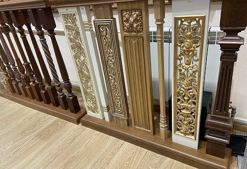 Photo of wooden balustrade for stairs with decorative carved panels and elements
