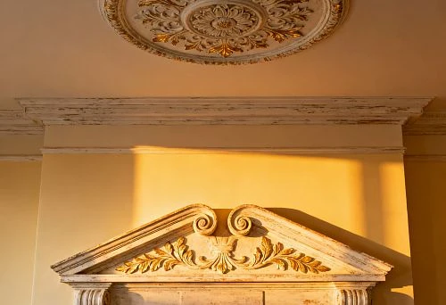 Gilded Ceiling Rosette and Carved Fireplace Gable in a Classic Interior
