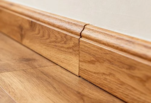 Wide wooden floor skirting board with natural oak texture