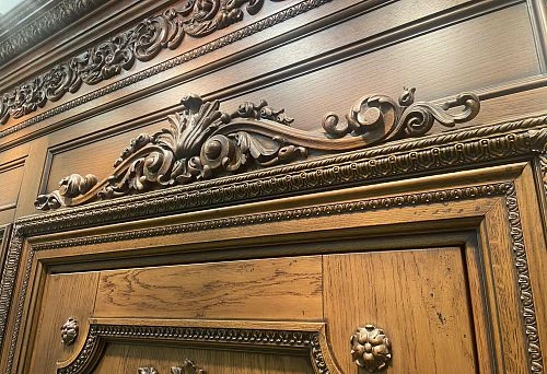 Sandro in architectural decoration above a wooden door frame