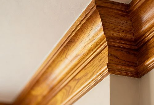 Wooden ceiling skirting in an interior corner, close-up