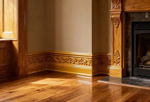 Decorative skirting boards with carved ornamentation by the fireplace.