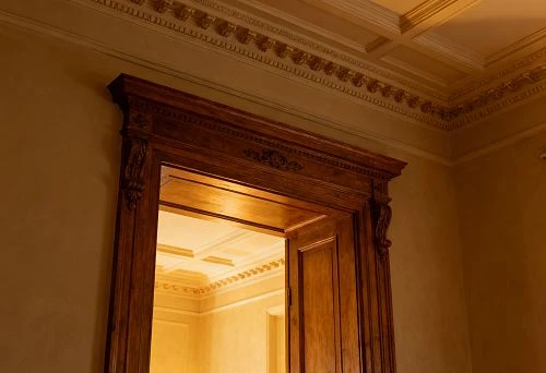 Classic interior with wooden door trim and decorative ceiling composition