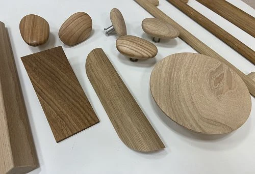 Various unfinished wooden handles and furniture elements in oval, round, and rectangular shapes