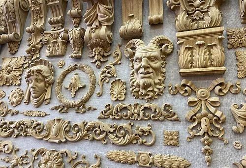 Collection of carved decorative oak elements &mdash; ornaments, mascarons, capitals, and appliqu&eacute;s