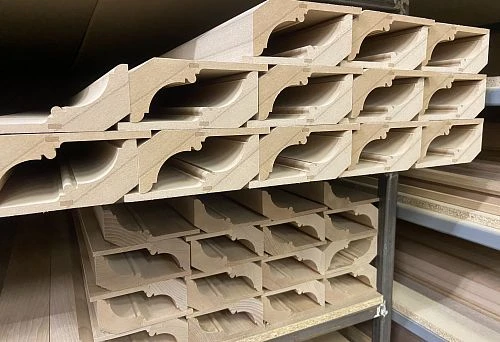 Straight rows of unpainted wooden frames with an elegant curved profile