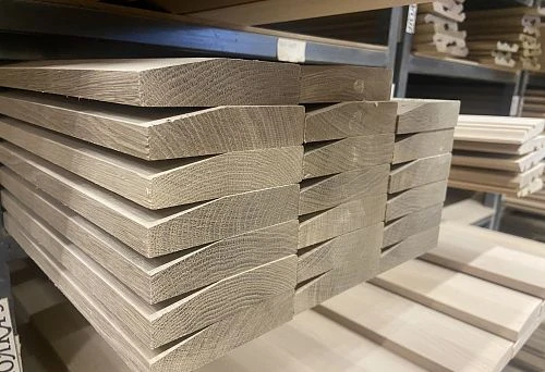 Stack of wooden baseboards on a metal shelf in a lumber store