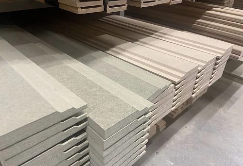 Stack of light-colored wooden skirting boards on warehouse shelves
