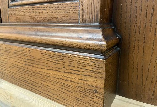 Decorative wooden skirting board in brown tone, mounted on the wall