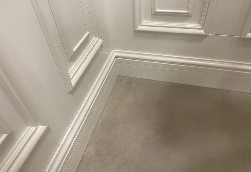 White heavy-duty skirting board along the wall with hidden wiring option