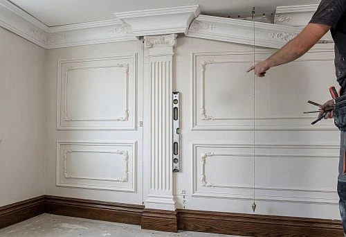Molding, pilaster, and wooden baseboard in the design of a classical wall