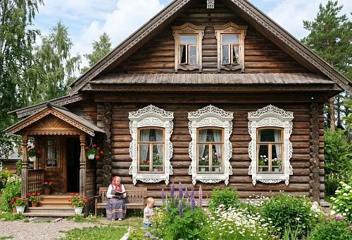 Carved window frames in Russian style on the facade of a wooden house