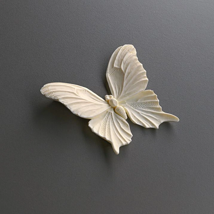 Room interior with a white chest of drawers decorated with polyurethane molding NPU-479 in the form of butterflies