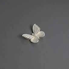 High white cabinet with golden polyurethane molding in the form of butterflies and branches.