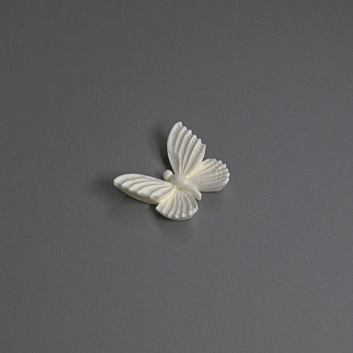 High white cabinet with golden polyurethane molding in the form of butterflies and branches.